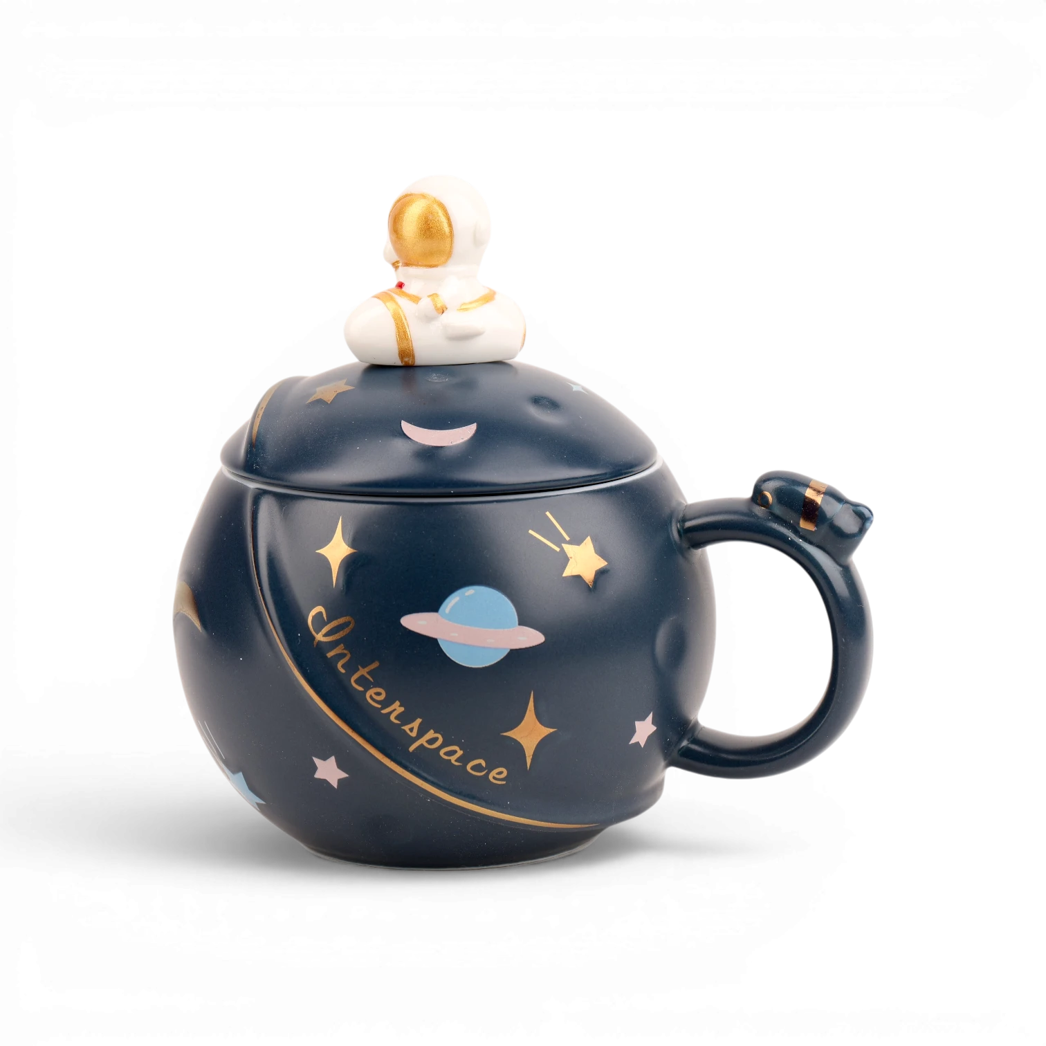 Dark navy ceramic mug with gold stars, planet, and astronaut lid topper design