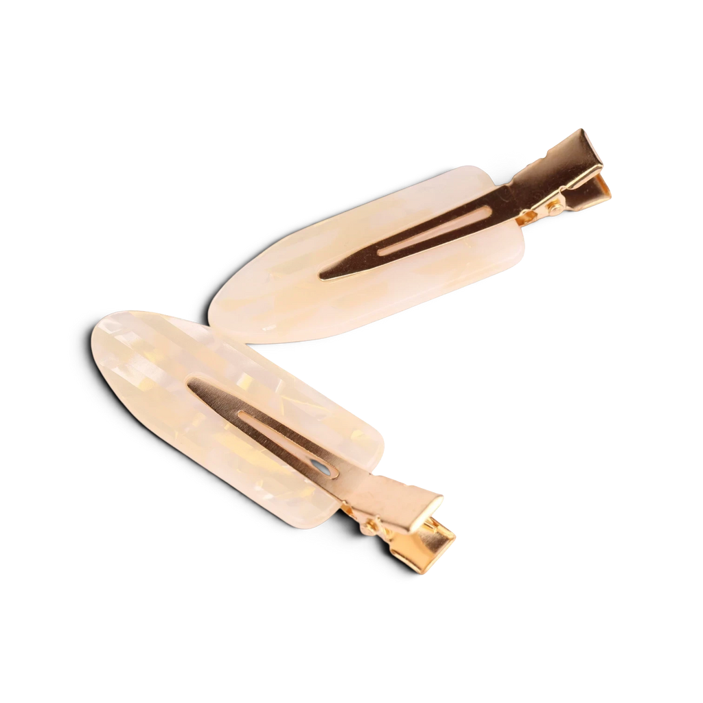Pair of cream acrylic resin hair clips with gold-tone metal hardware and brown tortoiseshell accents