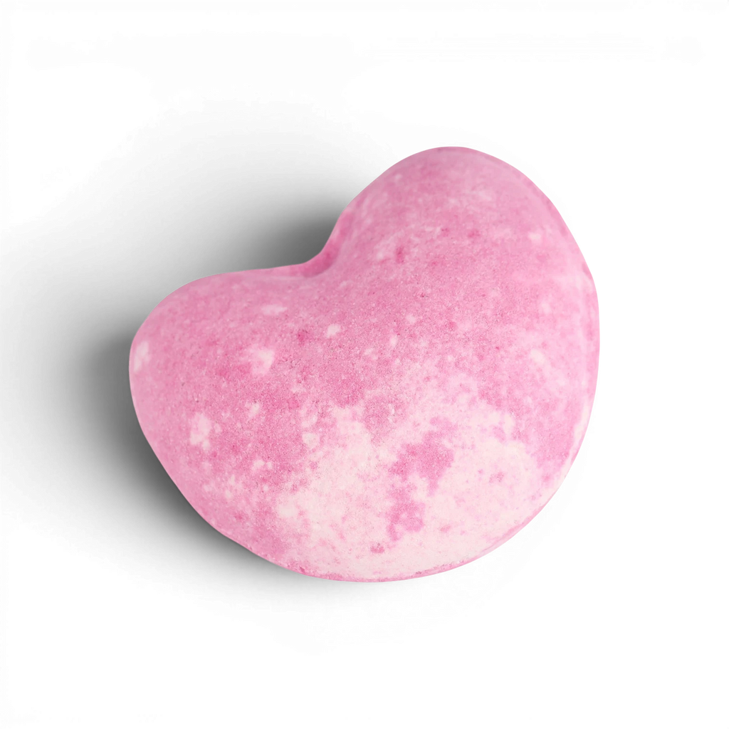 Pink heart-shaped bath bomb with speckled texture and curved design for fizzy bath time