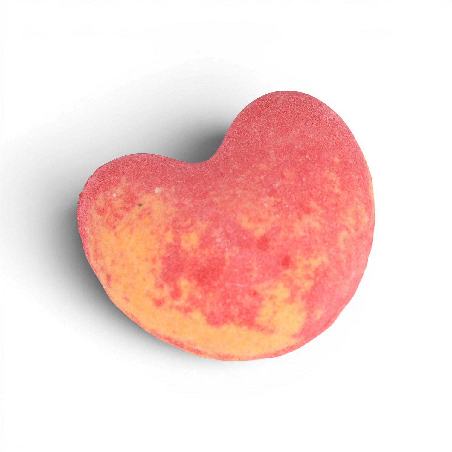 Red and yellow ombre heart-shaped bath bomb with fizzy texture and skin-nourishing oils