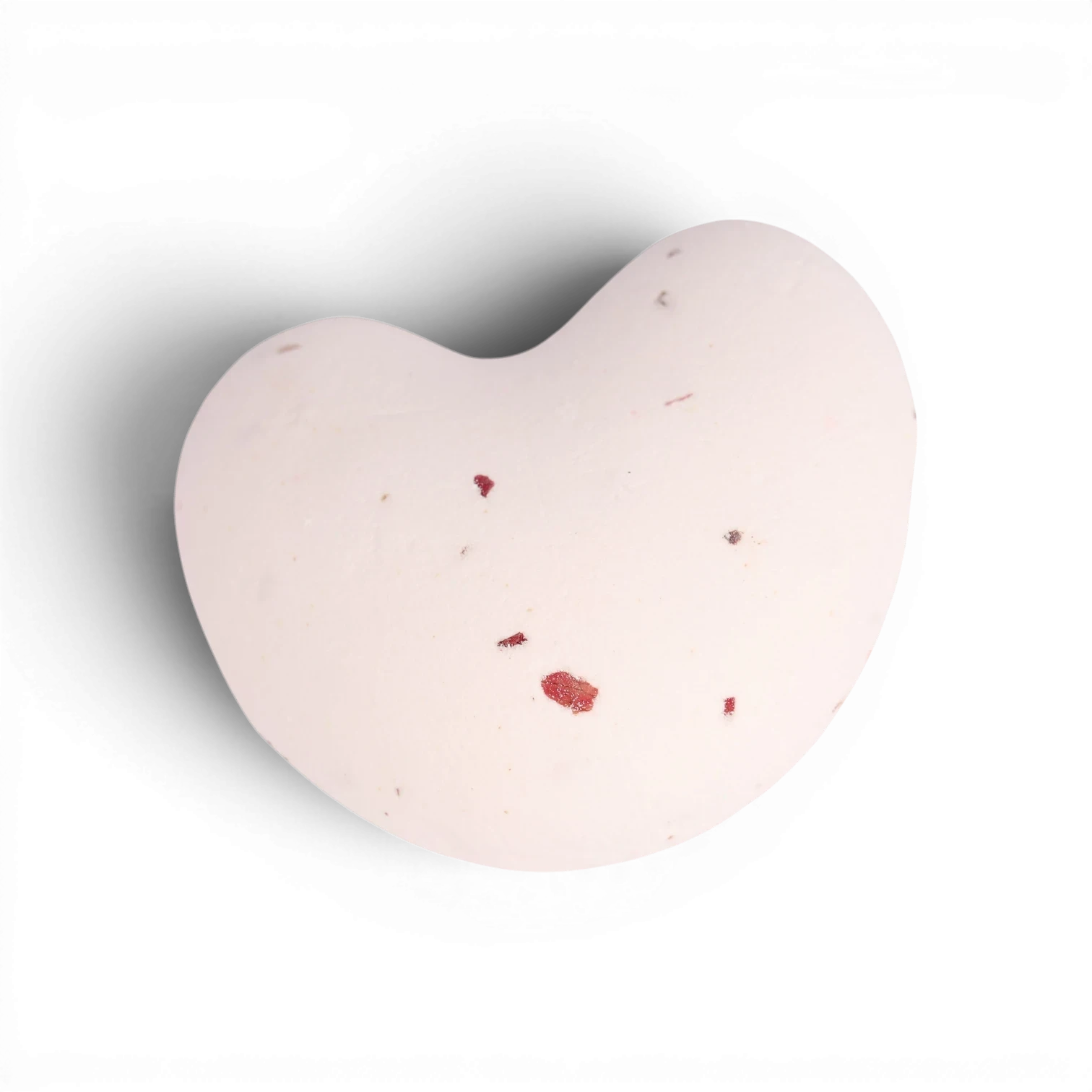 Pale pink heart-shaped bath bomb with red flower petals and natural botanicals embedded throughout