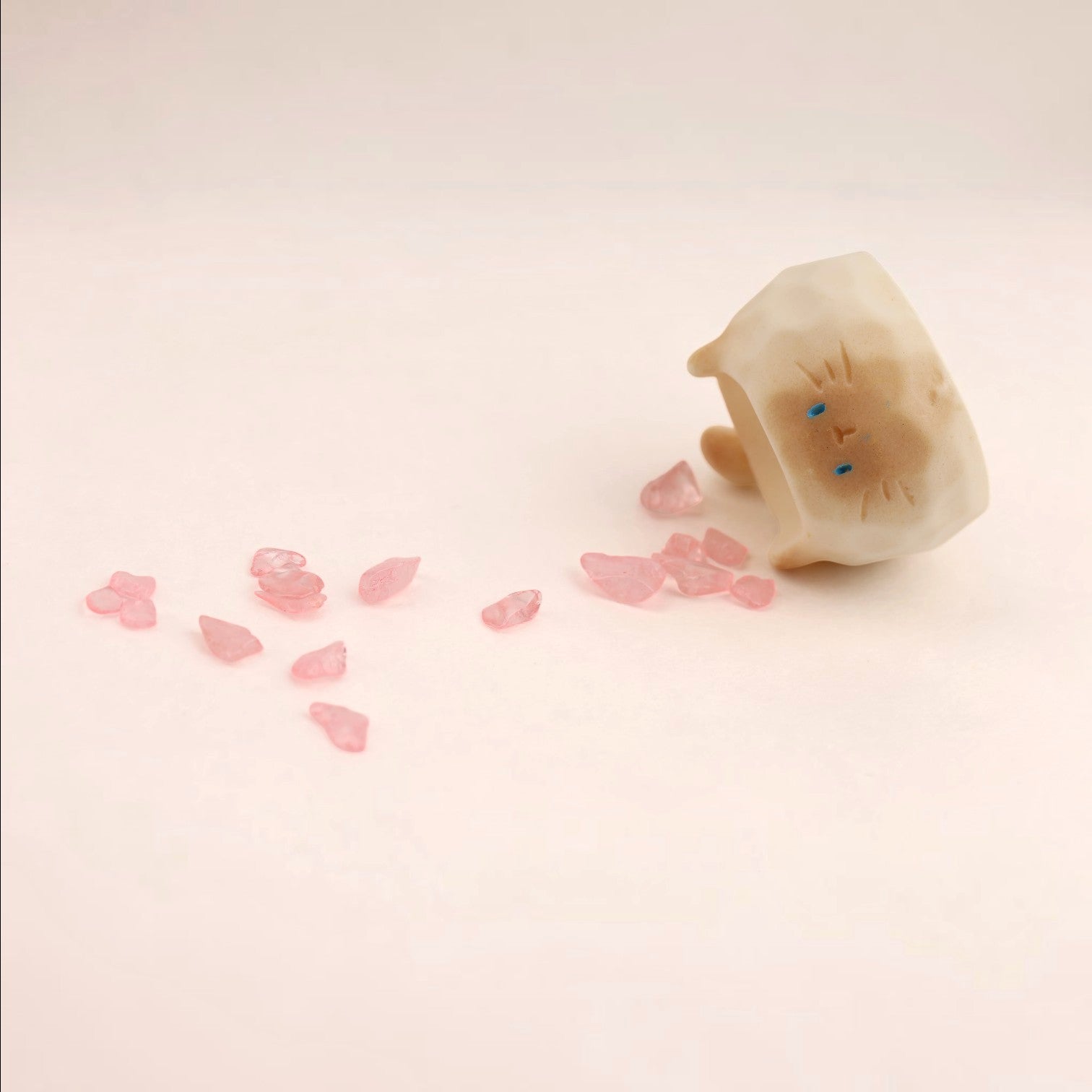 Figura de gato de Boxigami con acabado de cristal pulido, con pequeños fragmentos de cristal rosa esparcidos. Ideal como acento decorativo.