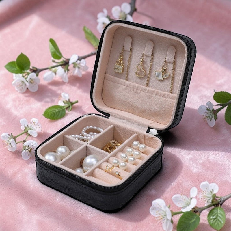 Boxigami joyero de viaje de cuero negro con interior forrado de terciopelo rosa, compartimentos para collares, anillos y pendientes.